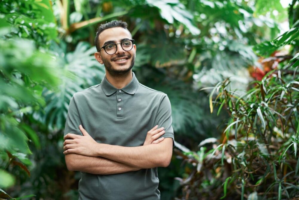 /young-man-in-green-polo-shirt-standing-in-tropical-garden.jpg