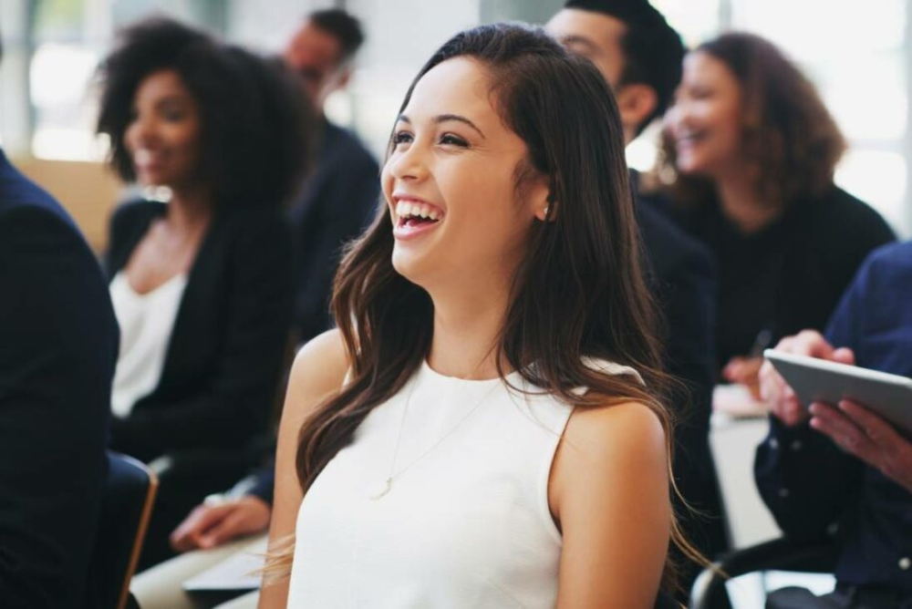 /young-woman-laughing-at-conference-presenter.jpg